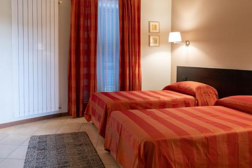 博尔戈马内罗HOTEL DEL CORSO的酒店客房设有两张床和窗户。