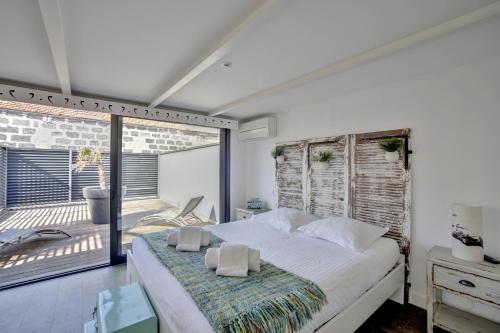 波尔多La Dependance by Cocoonr的一间带大床的卧室和一个阳台