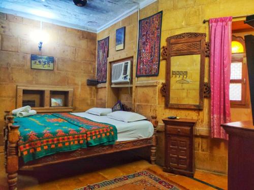 斋沙默尔Shahi Palace Hotel Jaisalmer的一间卧室配有一张床和镜子