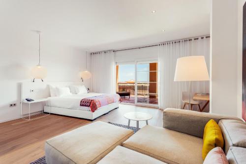伊斯兰蒂拉Ama Islantilla Resort的白色卧室配有床和沙发
