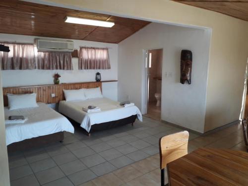 SeroweLentswe Lodge的酒店客房设有两张床和一张桌子。