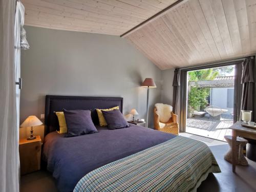 雷岛林滩Derrière la plage : suite, patio et pergola的一间卧室设有一张床和一个大窗户