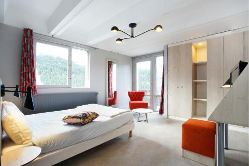 福勒恩Hôtel Club mmv Le Flaine ***的一间卧室配有一张床、一把椅子和窗户。