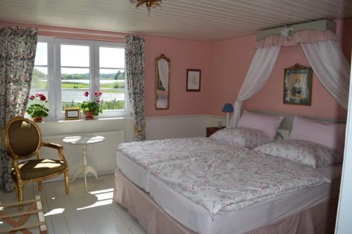 塞勒姆Bed & Breakfast mit Charme- Aux2platanes- Außergewöhnlich schön am Bodensee的一间卧室配有一张粉红色的墙壁和窗户。