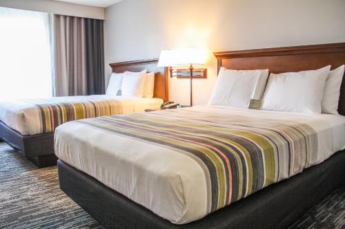 斯特灵卡尔森华盛顿杜勒斯机场江山旅馆&套房的酒店客房,设有两张床和一盏灯