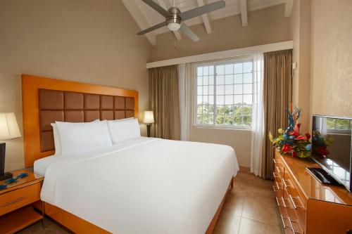 基督教堂市迪维南风海滩度假酒店的卧室配有一张白色大床和电视。