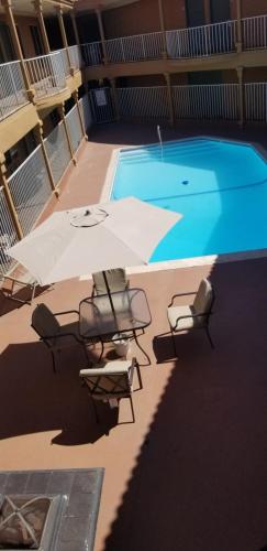 安大略Lotus by Hotel Inn的一个带椅子和遮阳伞的游泳池以及游泳池