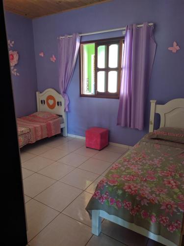韦尔卡鲍Village do Capão的一间卧室设有两张床和窗户。
