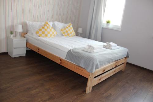 什切青SMM Apartament Stettin的一间卧室配有一张带黄色和白色枕头的大床