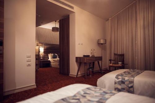 纳布卢斯Yaldiz Palace Hotel的酒店客房配有两张床和一张书桌