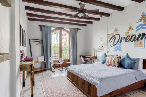 格拉纳达Selina Granada的一间卧室配有一张床和吊扇