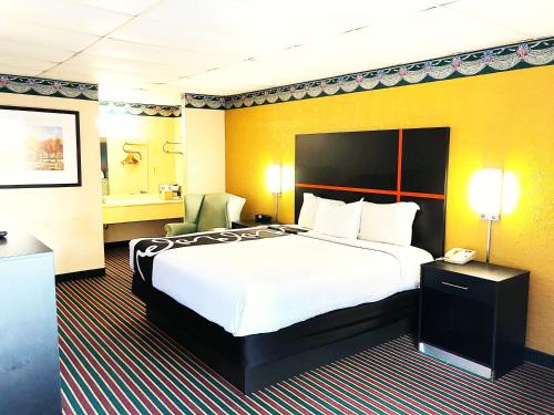 加兹登Rodeway Inn的配有一张大床和一部电话的酒店客房