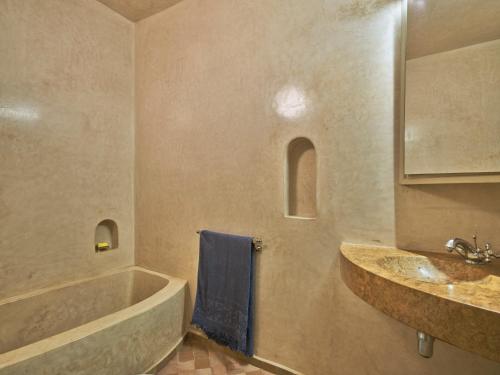 马拉喀什Riad Volubilis的带浴缸、水槽和蓝毛巾的浴室