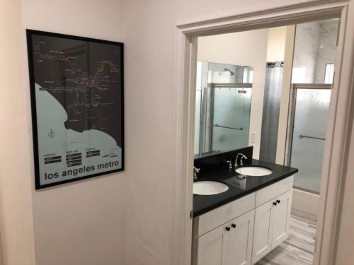 洛杉矶8th and Ardmore的浴室设有两个盥洗盆,墙上挂着一幅画