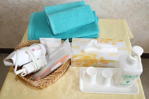 富士河口湖迈尔林基旅馆的一张桌子,上面有一篮毛巾和一瓶洗涤剂