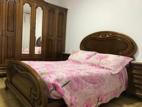 菲尼斯特雷Casa de Campo en Sardiñeiro de Arriba的一间卧室配有一张带粉红色棉被的木床