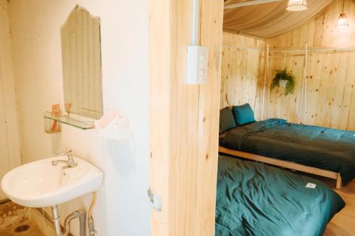 大叻Dalat Memories Homestay - Phố Sương Mờ Đà Lạt的一间带水槽的浴室和一张位于客房内的床