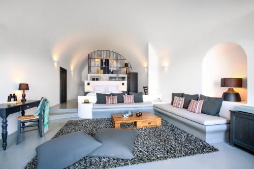 阿克罗蒂里Grand Ambassador Santorini Hotel的客厅配有沙发和桌子