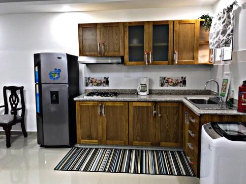 苏莎亚Fully Equipped New 1br Apt–dt–2mins To Beach的厨房配有木制橱柜和不锈钢冰箱。