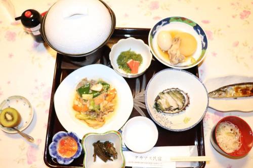 Ōtsuchiタカマス民宿的盘子上放着盘子,盘子上放着食物