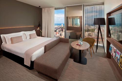 巴塞罗那美利亚巴塞罗那天空四星级酒店的酒店客房设有一张大床和一张桌子。