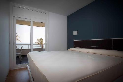 锡切斯Apartamentos Sunway Talaia的卧室设有一张白色大床和一扇窗户。