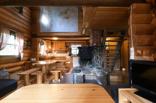 PelkosenniemiLaavu Holiday Homes的小屋内带桌子和壁炉的房间