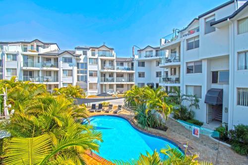 黄金海岸可伦宾海滩沙堡酒店的一座公寓大楼的图片,里面设有游泳池和棕榈树