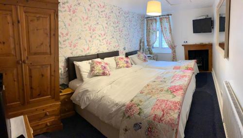马特洛克凯博斯旅馆的一间卧室配有一张带花卉壁纸的大床