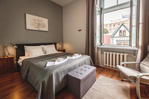 里加贝尔斯理市中心公寓的卧室配有床、椅子和窗户。