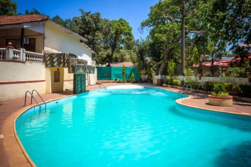 马泰兰Adamo The Village的一座大蓝色游泳池,位于房子前