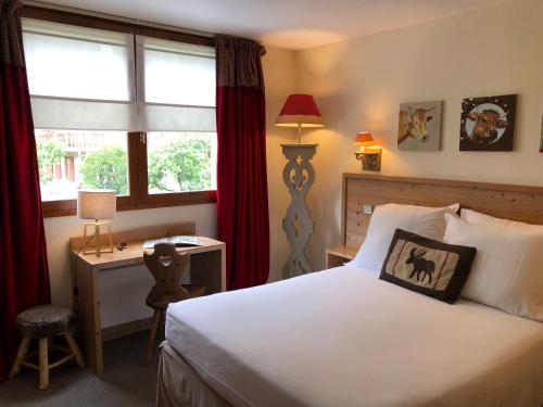 艾姆拉普拉涅图尔玛丽娜餐厅酒店的一间卧室配有一张床、一张书桌和一个窗户。