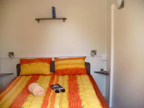 丽都斯皮纳Victoria Mobilehome in Camping Mare e Pineta的一间卧室配有一张床,上面有手机
