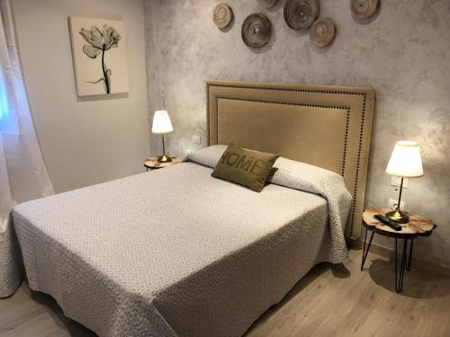 拉拉古纳La Laguna Luxe Apartment的一间卧室配有一张大床和两盏灯