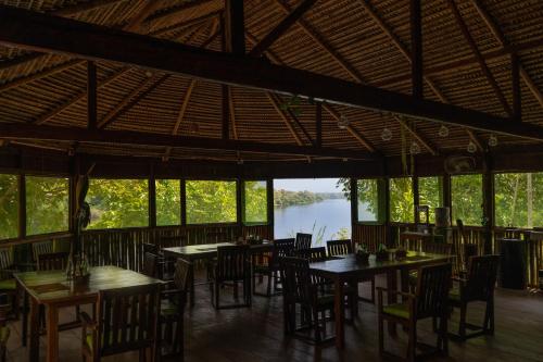 Careiro海豚酒店的一间带桌椅并享有河景的餐厅