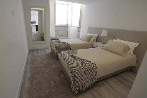 维亚纳堡Apartamento das Malheiras的一间卧室配有两张床和镜子