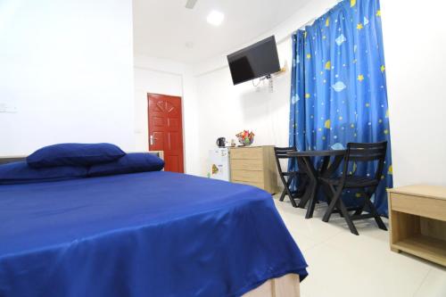马累Resting View的一间卧室配有蓝色的床和桌椅