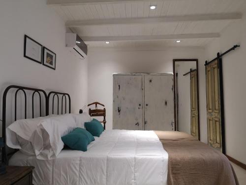 伊瓜苏港Rincón Escondido B&B的卧室配有带蓝色枕头的大型白色床