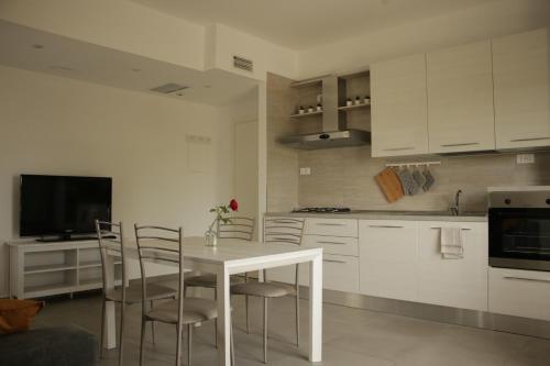 里米尼casa in campagna alle porte di Rimini 3min fiera 3 min mare的白色的厨房配有桌椅