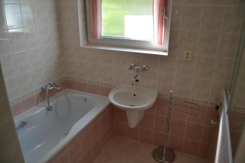 圣乔治Granny's的浴室配有盥洗盆、浴缸和卫生间。