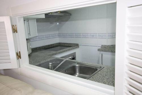 桑卢卡尔-德巴拉梅达Apartamento acogedor en lugar inmejorable的厨房配有水槽和镜子