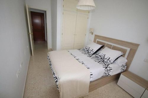 桑卢卡尔-德巴拉梅达Apartamento acogedor en lugar inmejorable的一间卧室配有带白色床单和枕头的床。