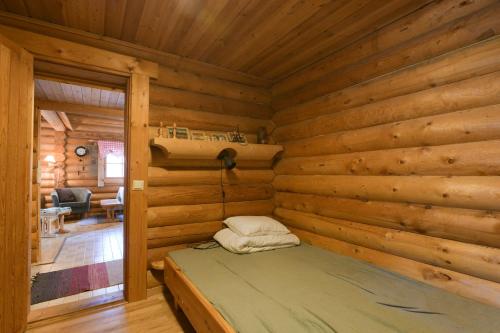 洛斯托Joutsen Holiday Home的小木屋卧室配有床