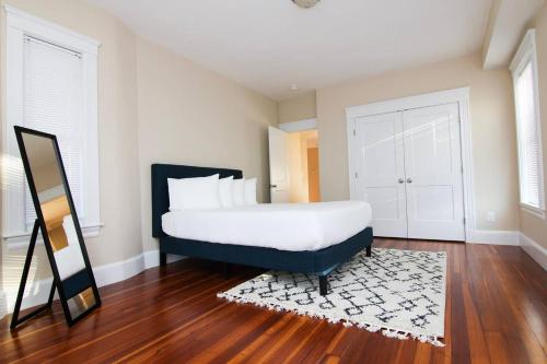 马尔登Luxury 3 Bedroom, 20 min to Boston, 15min Encore的一间卧室配有一张大床和镜子