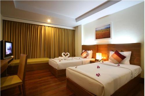 象岛坝安塞考广场酒店及服务式公寓的酒店客房设有两张床和电视。