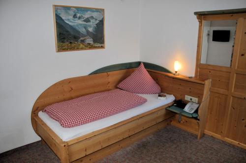 加尔蒂Pension Belvedere的一间卧室配有一张木床和电话