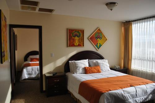 拉塔昆加MAK INN HOUSE的一间卧室配有一张带橙色毯子和镜子的床