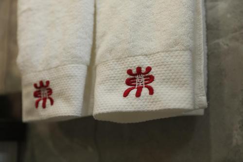 北京北京东堂轻奢酒店的毛巾上带红色刺绣的两张餐巾纸
