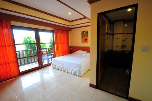 象岛艾莉娜大酒店&度假村的一间卧室配有一张床,浴室设有阳台