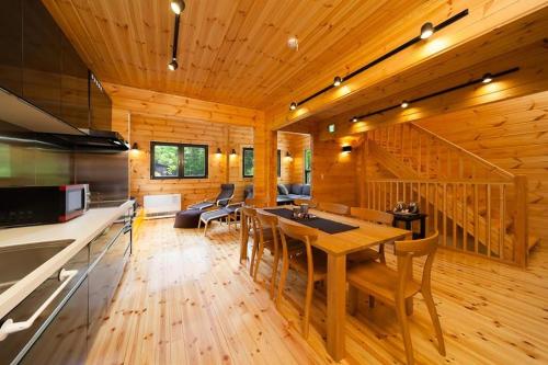 白马村Wadano Woods by Hakuba Hotel Group的厨房以及带桌椅的起居室。